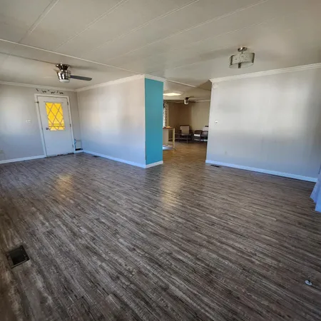 a view of empty room with a window and wooden floor