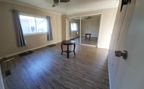 a view of a hallway with wooden floor and windows