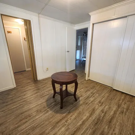 a view of a room with wooden floor and a hallway