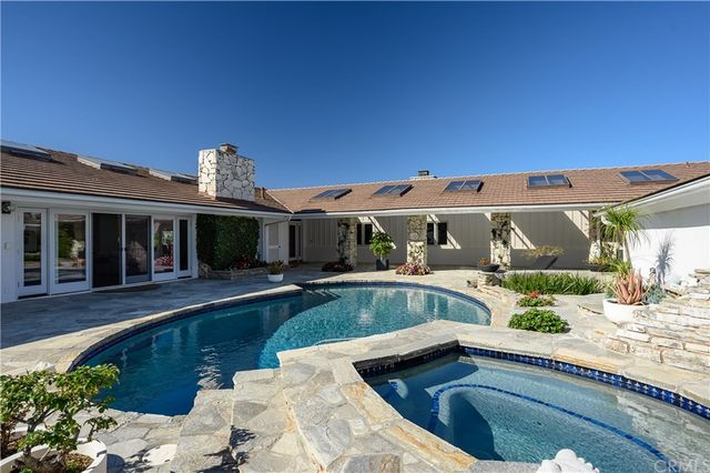 a aerial view of a house next to a big yard with plants and large trees