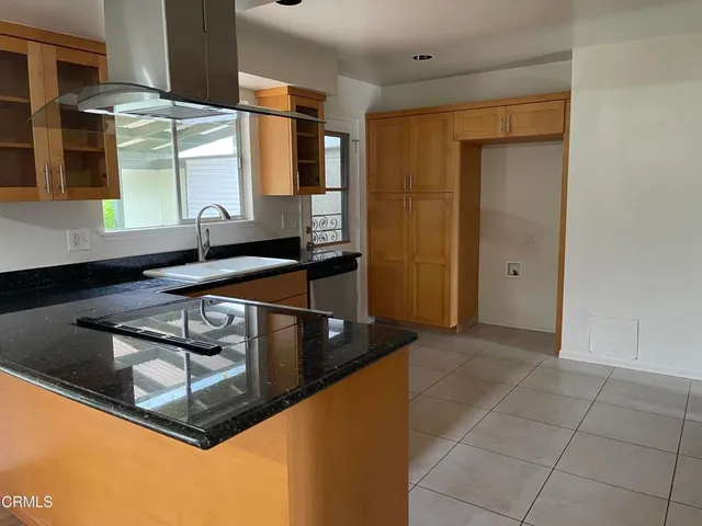 a kitchen with stainless steel appliances granite countertop a sink and a refrigerator