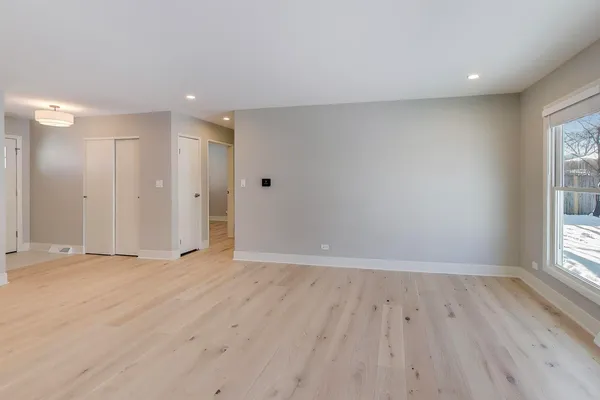 a view of an empty room and a kitchen