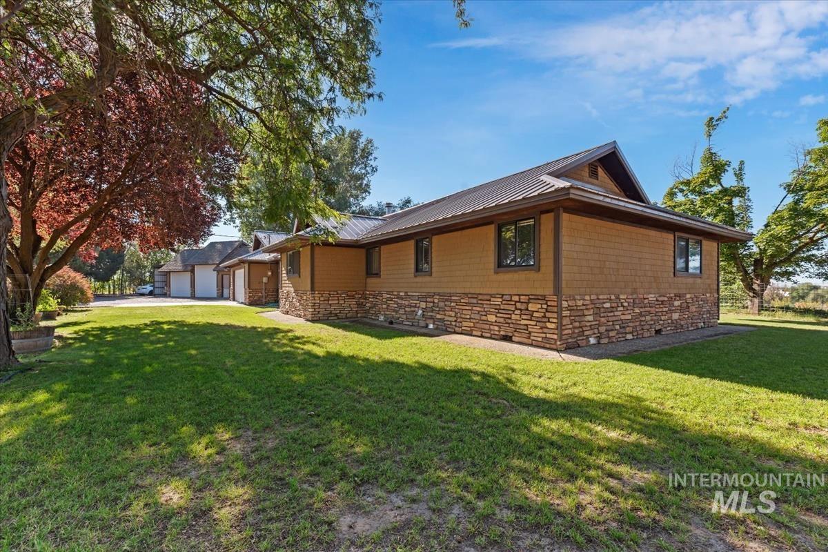 8275 Washoe Road Fruitland, ID 83619 - Photo 36 of 43 Exterior featuring a metal roof, shingle siding, and a stone veneer foundation