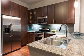 2525 McCue Road, Unit 535 Houston, TX 77056 - Photo 4 of 16 a kitchen with granite countertop a refrigerator and a sink