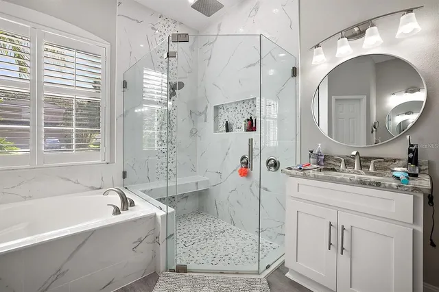 a bathroom with a tub sink and mirror