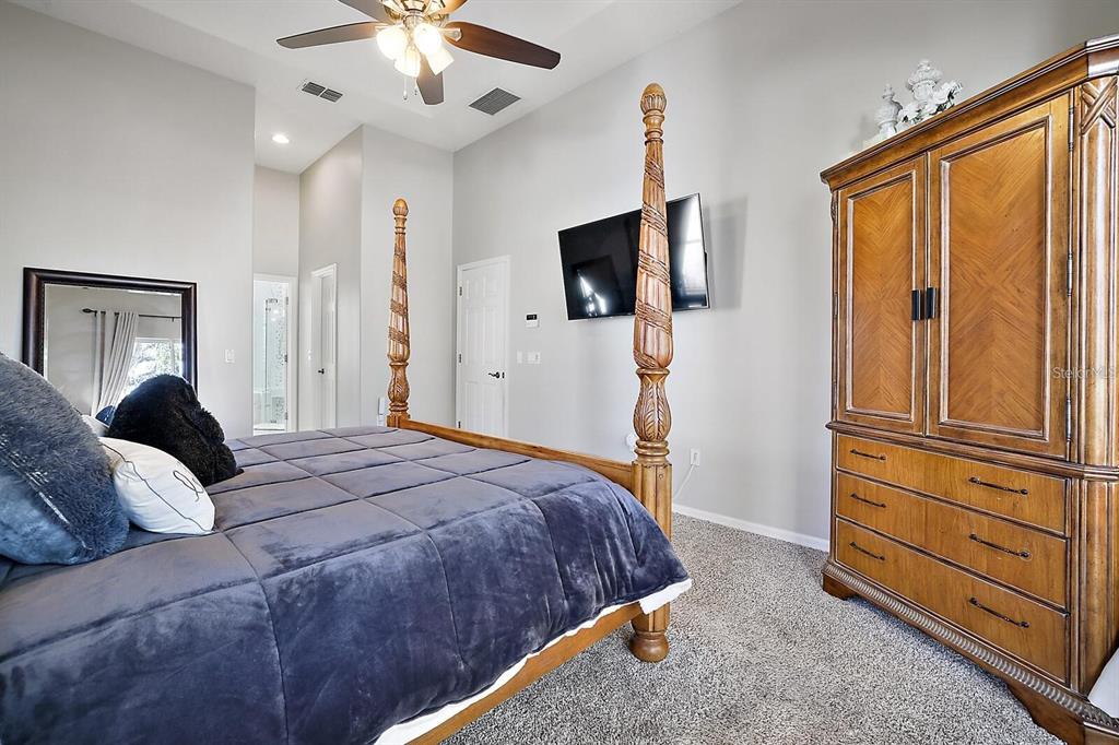 2847 Majestic Isle Drive Clermont, FL 34711 - Photo 15 of 25 a bedroom with a large bed and flat tv screen