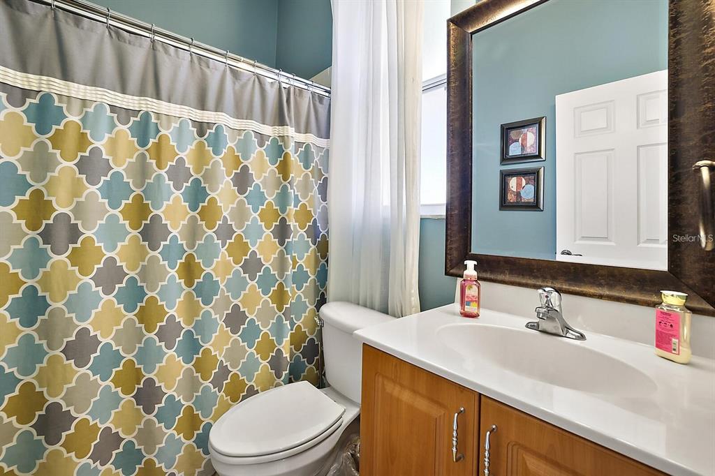 2847 Majestic Isle Drive Clermont, FL 34711 - Photo 20 of 25 a bathroom with a sink a toilet and shower curtain