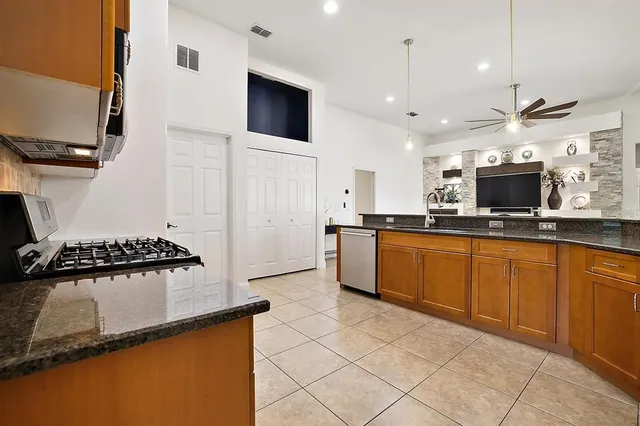 a kitchen with stainless steel appliances granite countertop a sink and a stove