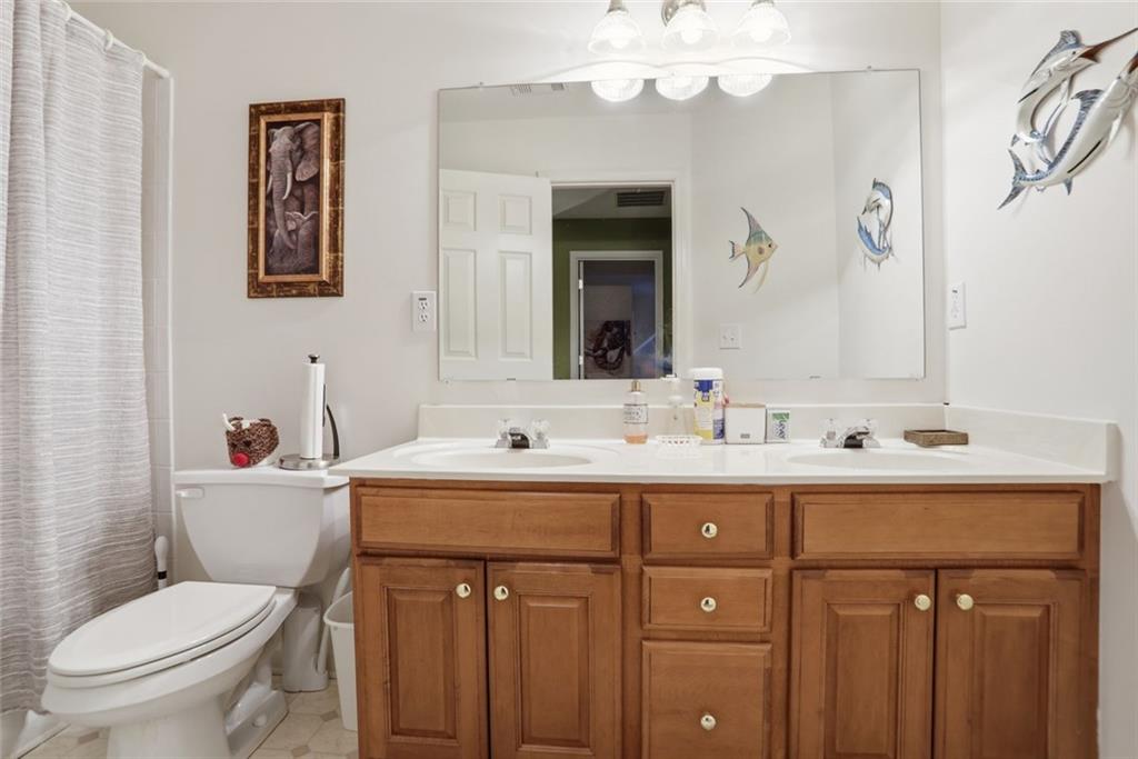 632 Grande View Stone Mountain, GA 30087 - Photo 24 of 46 a bathroom with a toilet a sink a mirror and a shower