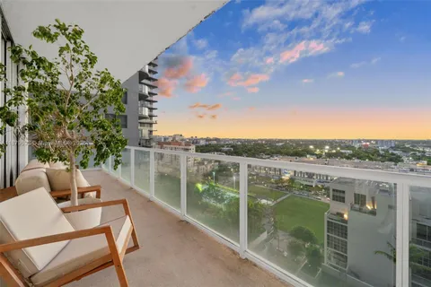 a view of a terrace with lawn chairs and wooden fence