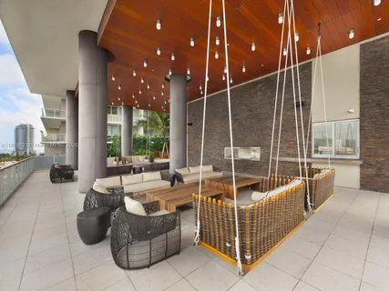 a living room with patio furniture and a garden