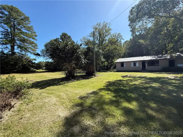 a view of a house with yard and sitting area