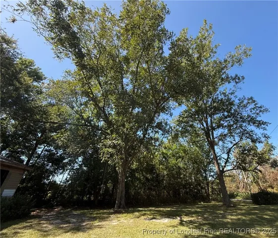 a view of a large pool with lawn chairs under an umbrella