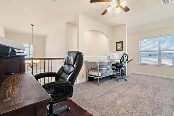 a view of a workspace with furniture and a window