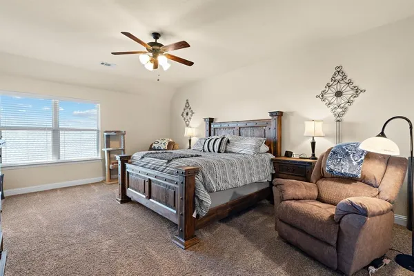 a bedroom with a bed couches and window