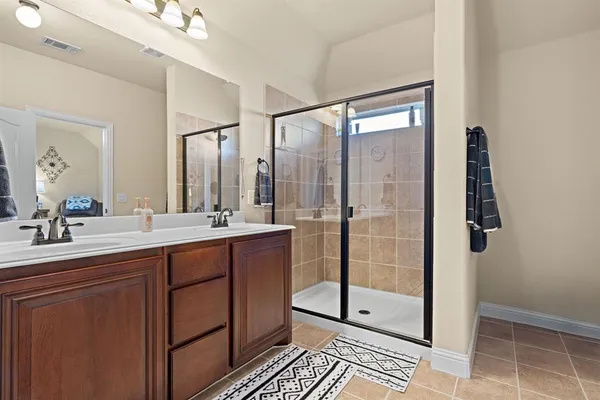 a bathroom with a shower sink and mirror