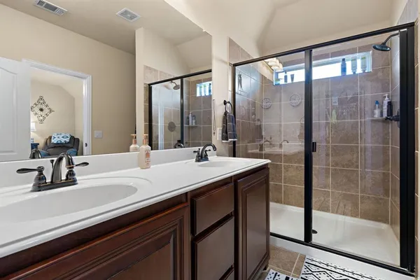 a bathroom with a shower sink and mirror