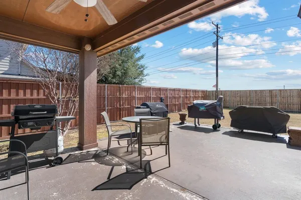 a view of a patio with table and chairs and potted plants