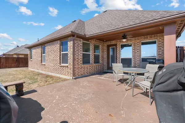a view of a house with backyard and sitting area