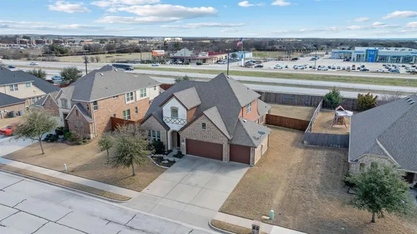an aerial view of a house with a yard and ocean view