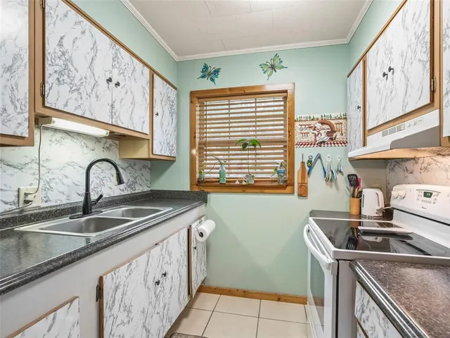 a kitchen with stainless steel appliances granite countertop a sink and a stove next to a window