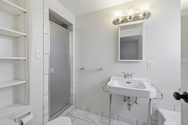 a bathroom with a sink toilet and shower