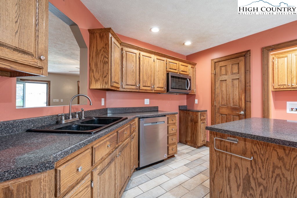 621 Trivette Hollow Road Creston, NC 28615 - Photo 18 of 43 a kitchen with stainless steel appliances granite countertop a sink stove and cabinets