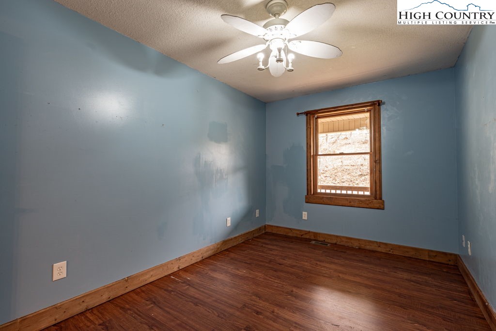 621 Trivette Hollow Road Creston, NC 28615 - Photo 27 of 43 an empty room with wooden floor chandelier and windows