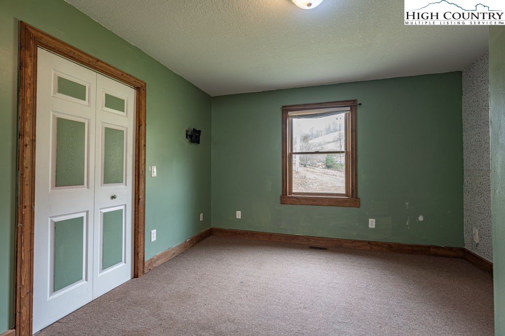 621 Trivette Hollow Road Creston, NC 28615 - Photo 33 of 43 an empty room with a window and a ceiling fan
