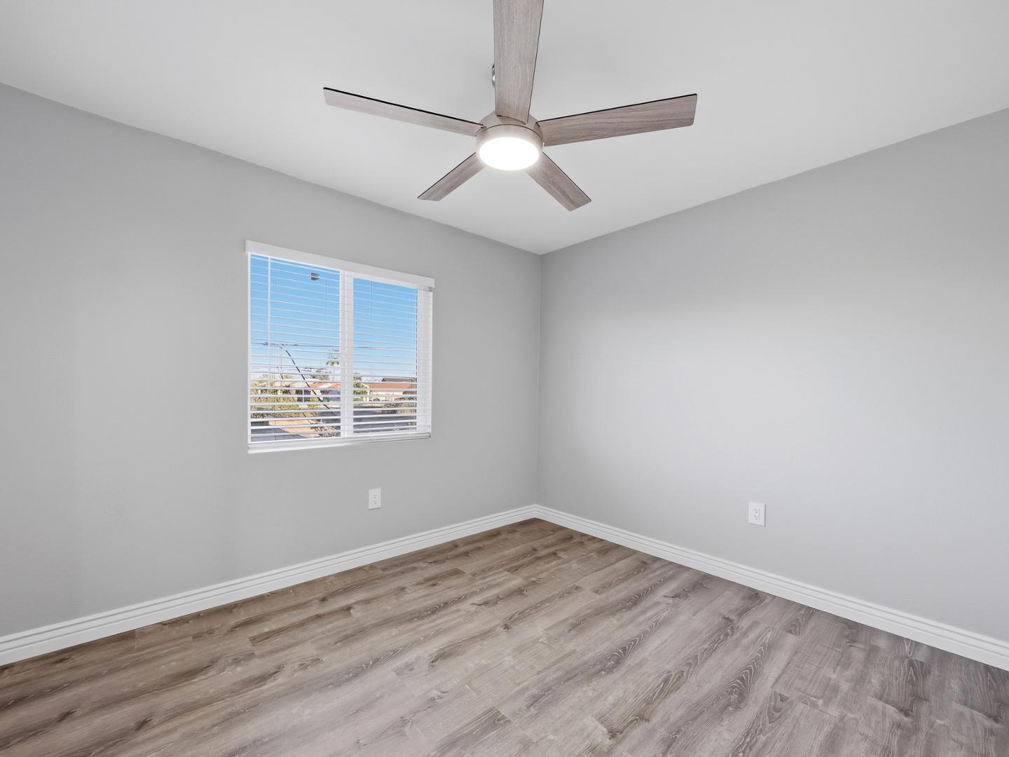 127 South Outpost Road, Unit 4 Apache Junction, AZ 85119 - Photo 11 of 13 an empty room with wooden floor and windows