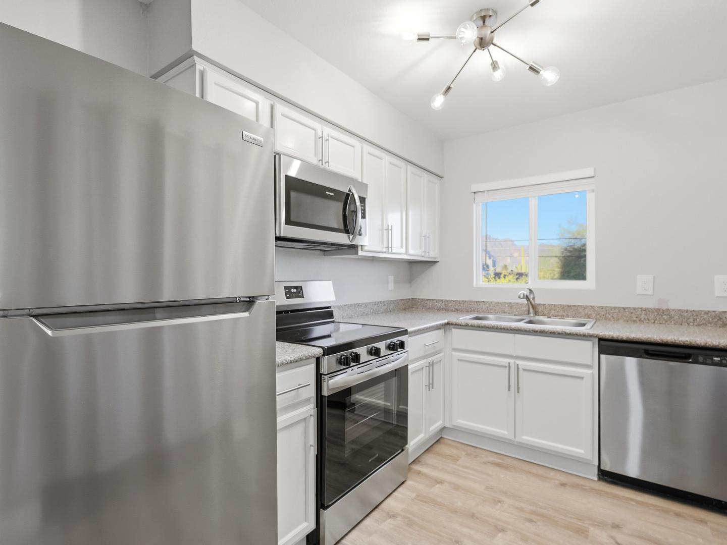 127 South Outpost Road, Unit 4 Apache Junction, AZ 85119 - Photo 8 of 13 a kitchen with stainless steel appliances a refrigerator sink and white cabinets