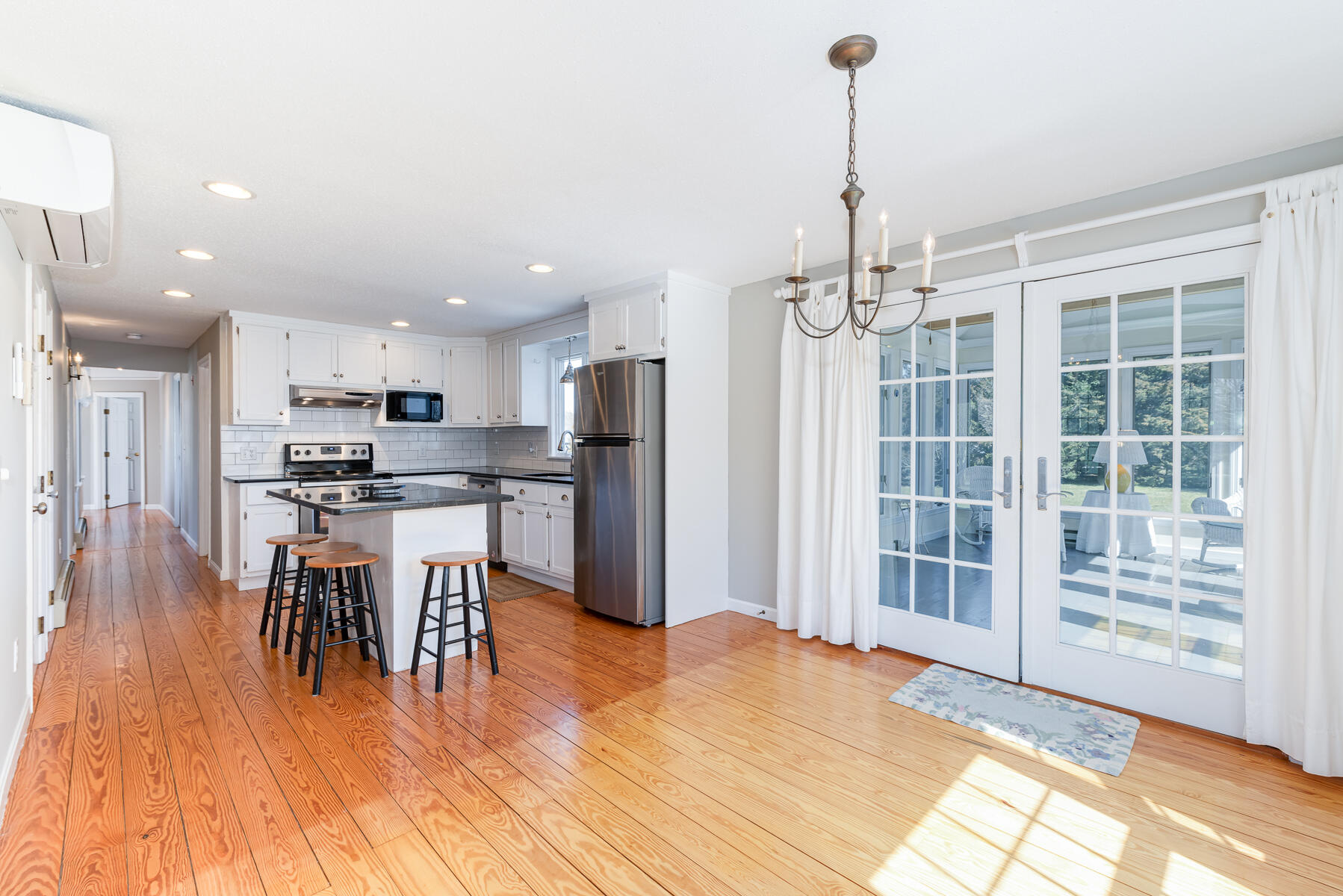 11 Pleasant View Drive Orleans, MA 02653 - Photo 12 of 47 a kitchen with stainless steel appliances kitchen island granite countertop a refrigerator a stove a microwave oven a dining table and chairs with wooden floor