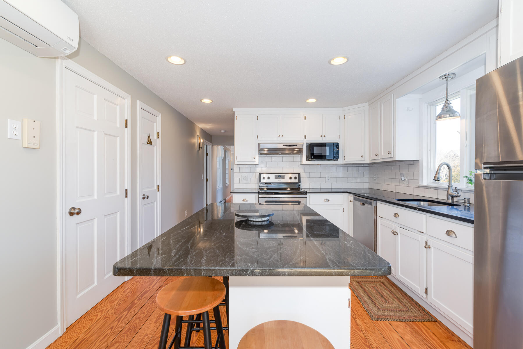 11 Pleasant View Drive Orleans, MA 02653 - Photo 15 of 47 a kitchen with stainless steel appliances granite countertop a refrigerator a stove top oven a sink dishwasher and white cabinets with wooden floor