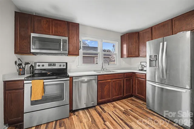 a kitchen with stainless steel appliances granite countertop a refrigerator stove top oven and sink