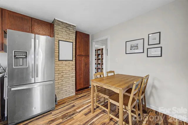 a kitchen with stainless steel appliances wooden floor and a refrigerator