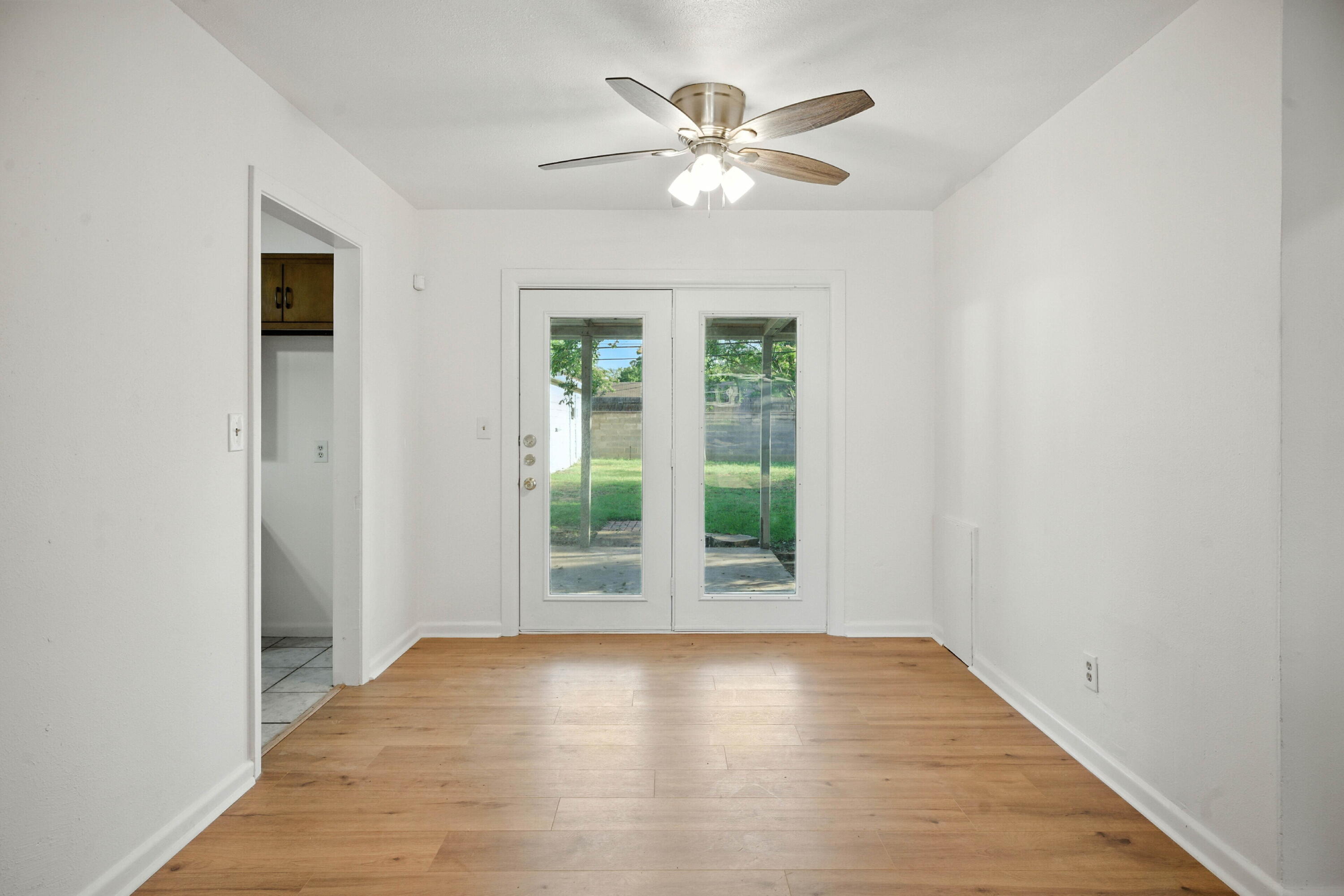4316 31st Street Lubbock, TX 79410 - Photo 2 of 12 an empty room with wooden floor chandelier fan and windows