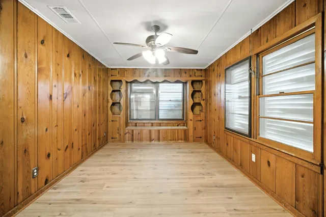 a view of a hallway with wooden floor and chandelier