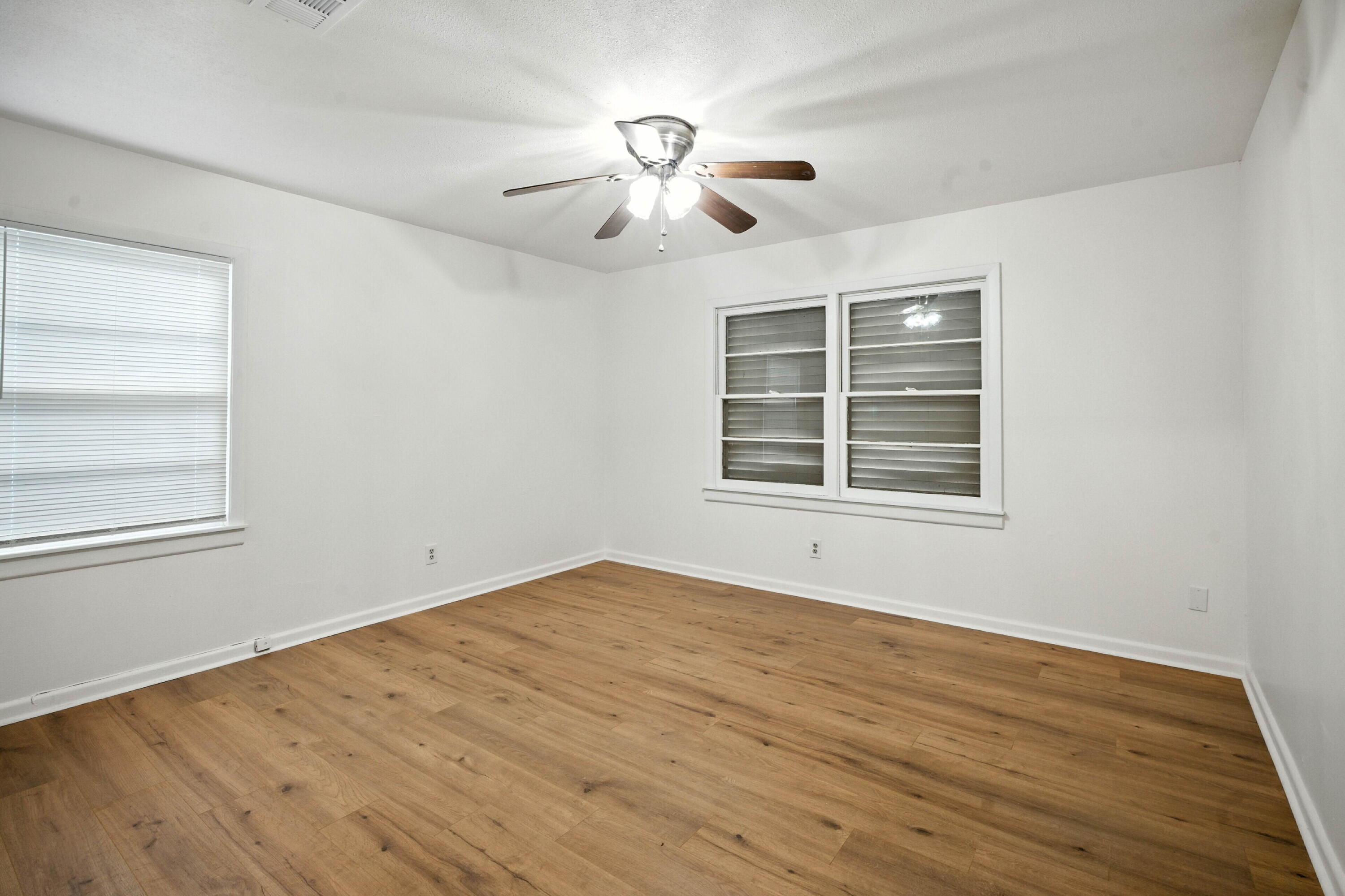 4316 31st Street Lubbock, TX 79410 - Photo 6 of 12 a view of empty room with wooden floor and fan