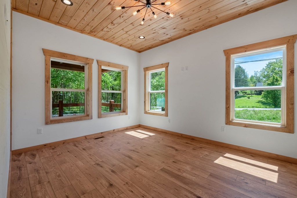 168 Ewing Street Blue Ridge, GA 30513 - Photo 32 of 46 a view of an empty room with wooden floor and a window