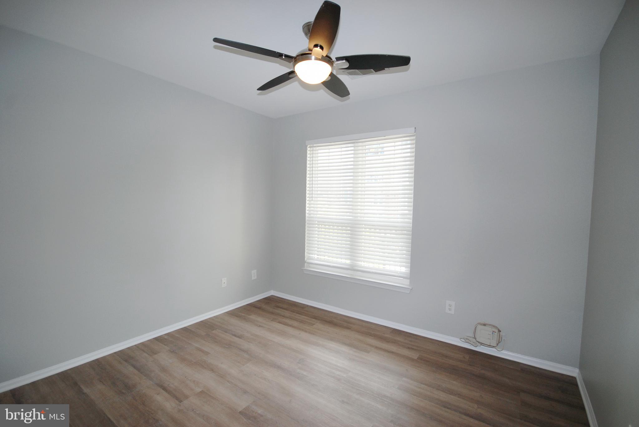 1571 Spring Gate Dr., Unit 6209 McLean, VA 22102 - Photo 18 of 31 an empty room with wooden floor ceiling fan and windows