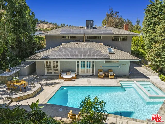 an aerial view of a house with swimming pool garden and patio