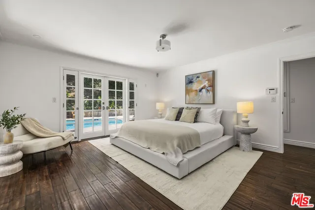 a spacious bedroom with a bed and wooden floor