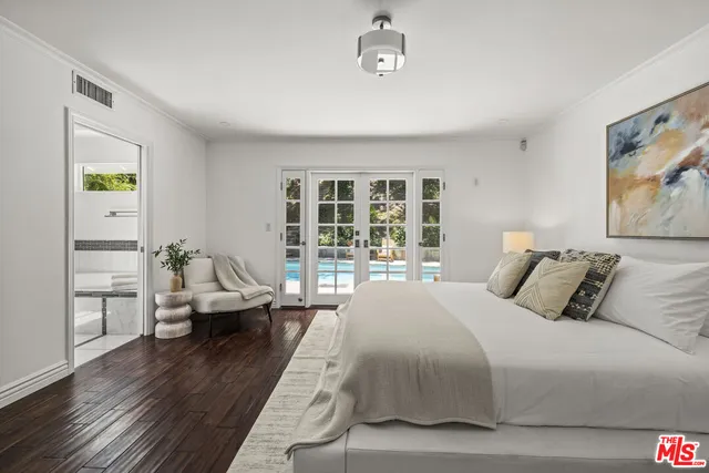 a large bedroom with a bed and wooden floor