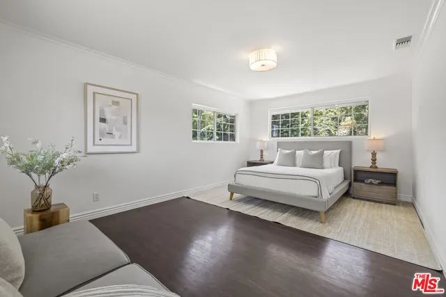 a bedroom with a bed and a potted plant