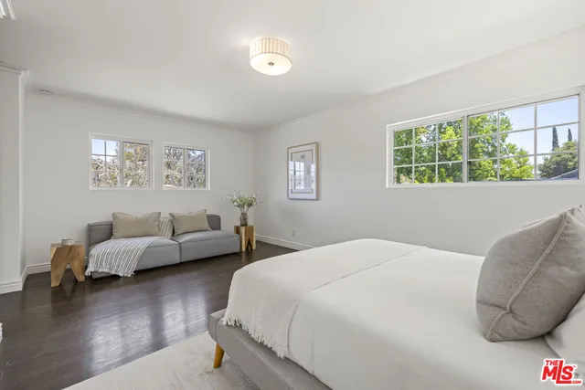 a bedroom with bed couch and window