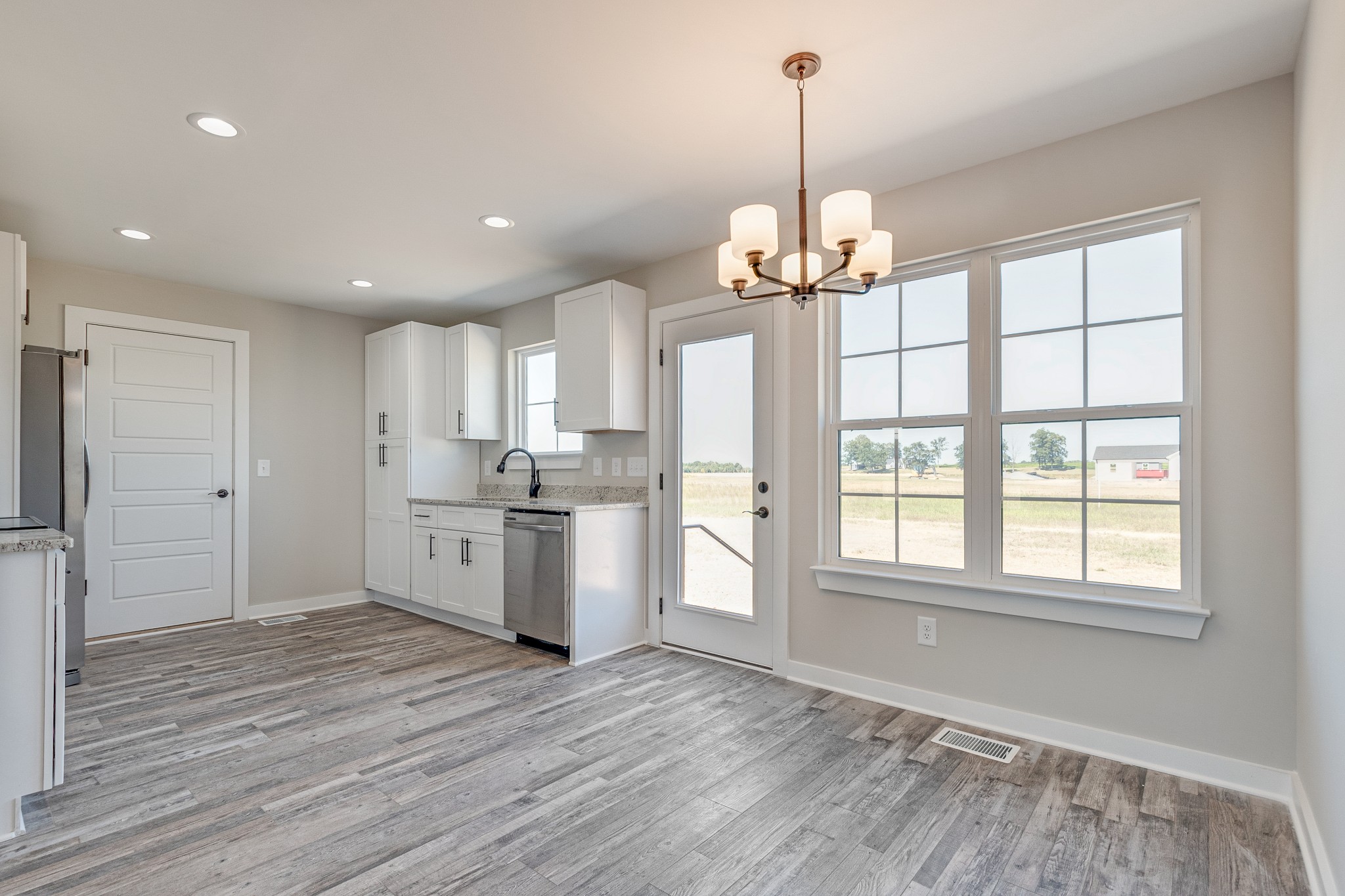 483 Meadows Road Portland, TN 37148 - Photo 13 of 29 a kitchen with stainless steel appliances granite countertop a refrigerator a sink dishwasher and a wooden floor