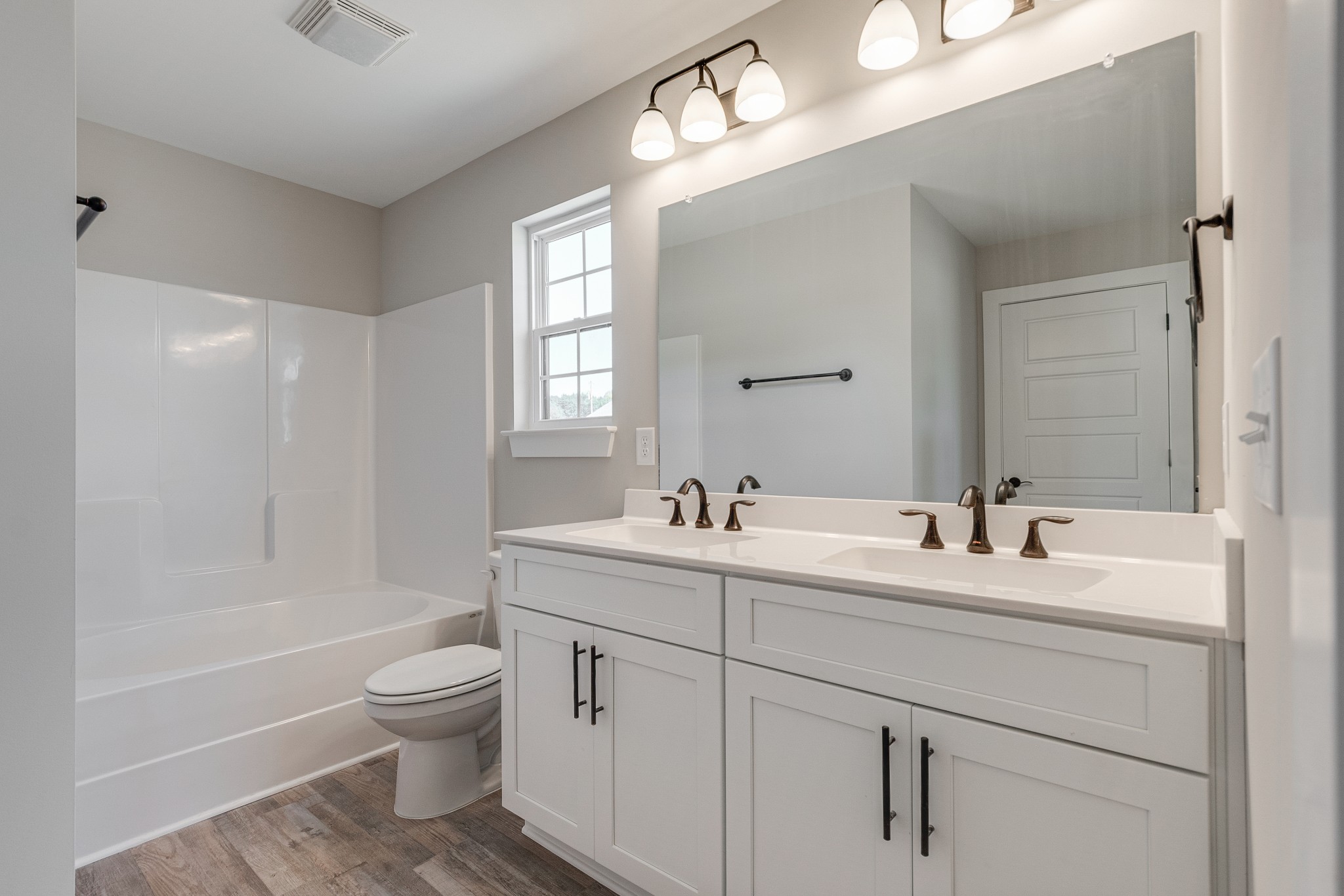 483 Meadows Road Portland, TN 37148 - Photo 20 of 29 a bathroom with a toilet a sink a mirror a bathtub and vanity