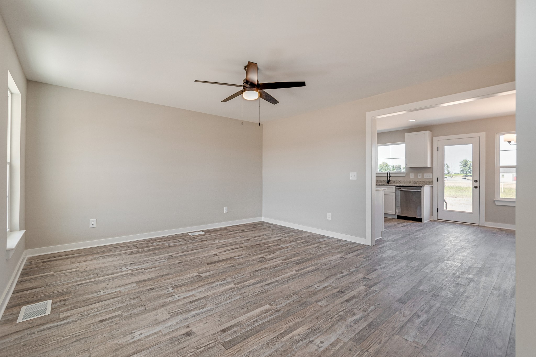 483 Meadows Road Portland, TN 37148 - Photo 6 of 29 wooden floor in an empty room with a kitchen