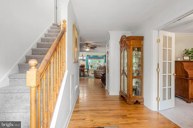 a view of a hallway with wooden floor and staircase