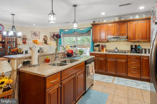 a kitchen with stainless steel appliances granite countertop a sink a stove and a refrigerator